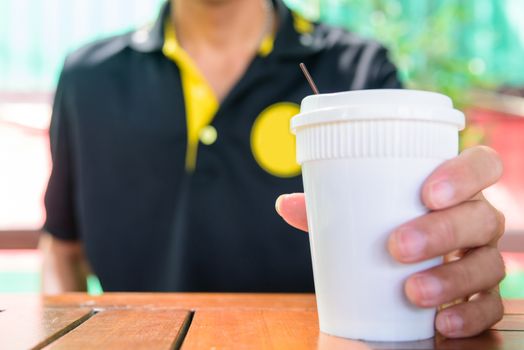 The man hold Paper cup of hot coffee for drink