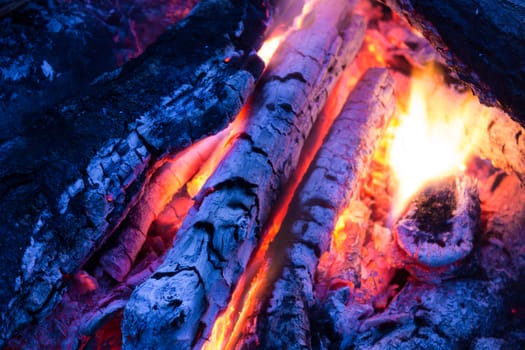 Burning and smoldering firewood in the fire in the evening in the open air