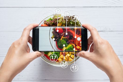 Calories counting and food control concept. woman using application on smartphone for scanning the amount of calories in the food before eat