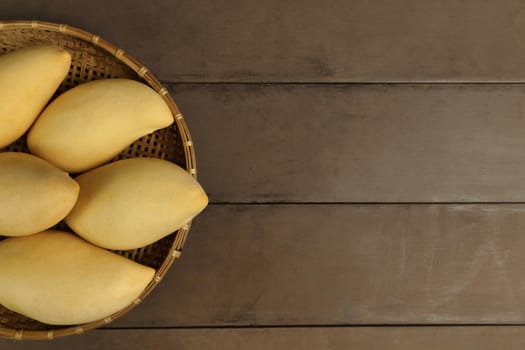 Top view Yellow Fresh mangos on real wood table. Mango tropical fruit on wood background. mangos with copy space.