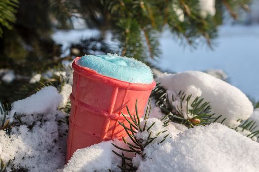 Ice cream in a waffle glass lies on fir branches