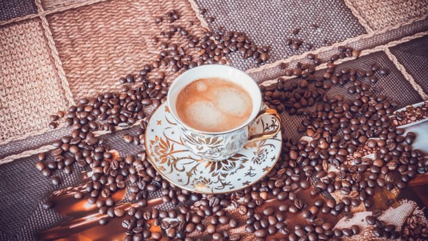 Cup of morning fresh fragrant coffee on a table with grains