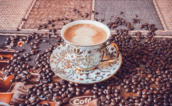 Cup of morning fresh fragrant coffee on a table with grains