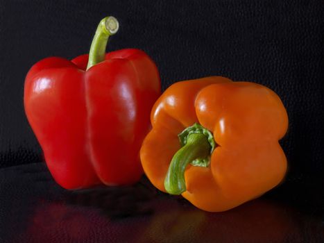 Voluptuous ripe colourful red and orange Bell Peppers in close up