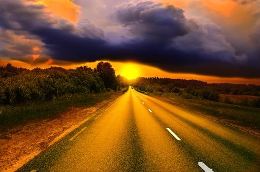 Driving on an empty road at lovely sunny day. Sun rising over asphalt country open road in sunny morning or evening. Open road at sunny sunset or sunrise time