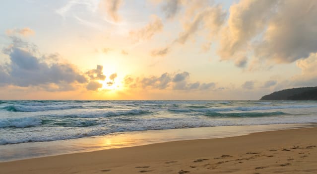 A beautiful sunset in the sea is observed from the sandy beach