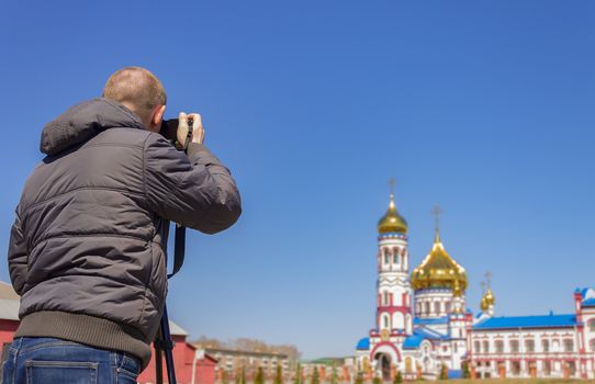 A photographer takes pictures of the church on camera with a tripod