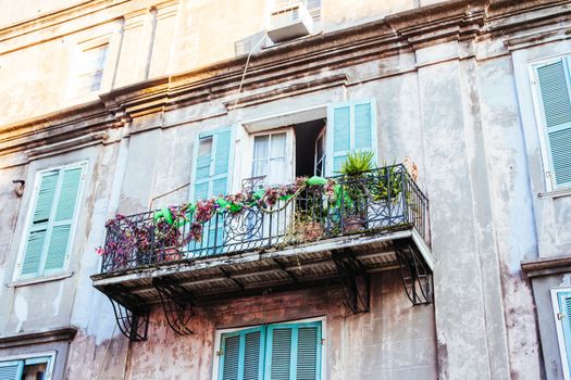 Flowers in baskets hang off shutter doors during Mardi Gras in New Orleans, Louisiana, USA