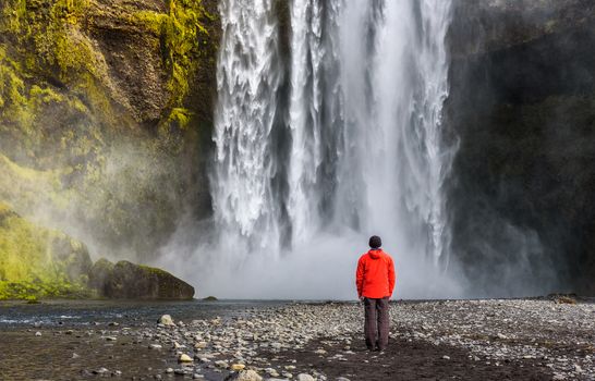 Tourist looking at the famous Skogafoss waterfall in southern Iceland