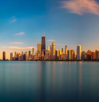 Chicago skyline across Lake Michigan at sunset viewed from North Avenue Beach. Long exposure.