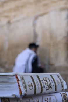 JERUSALEM - JULY 31 - Orthodox Jews prays at the Western Wall, behind praying book (Siddur) - July 31, 2013 in the old city of Jerusalem, Israel. This is the holiest place in Jewish tradition