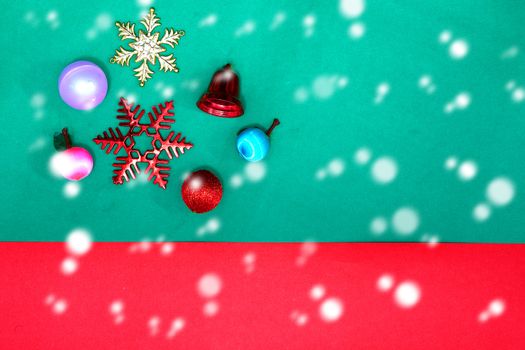 Christmas bauble, snowflake fruits and ring bell on Red green background with snow fall,top view with copy space