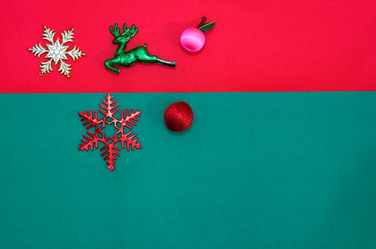 Christmas bauble,snow flake ,presents ,reindeer and leaves on Red green background with snow fall,top  view with copy space