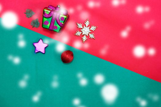Christmas bauble,snow flake ,presents ,star and leaves on Red green background with snow fall,top view with copy space
