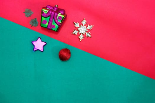 Christmas present,stra,baubles,snow flake and leaves on Red green background,top  view with copy space
