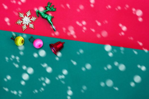 Christmas reindeer snowflake fruits and bell on Red green background with golden snow fall,top  view with copy space