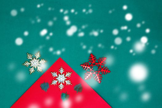 Christmas snow flake and leaves on Red green background,top  view and copy space with snow fall