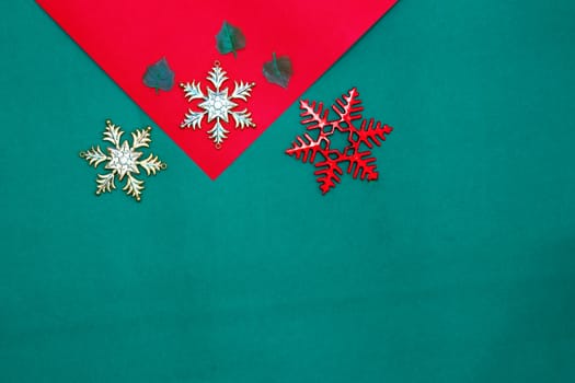 Christmas snow flake and leaves on Red green background,top  view and copy space