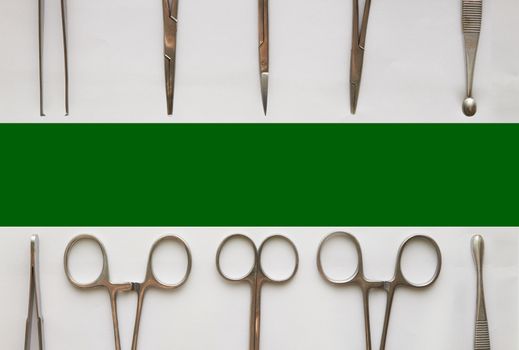 Doctor tools ,curettage ,cramps,forceps and scissors on isolated white background with green copy space