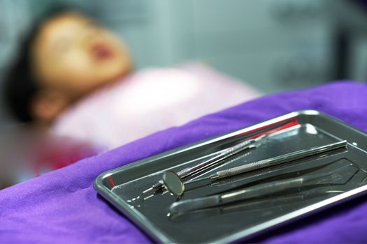 Dentist tools on tray on blur background