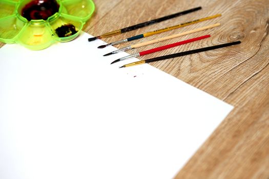 mock up of Paper of art work with color plate and color brushes, side view