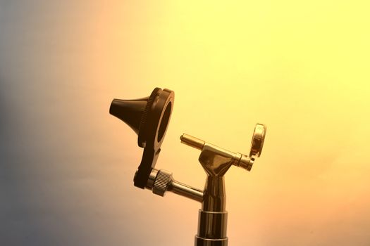 Otoscope for ENT doctor exam ear head cone piece view on white background with sun flare