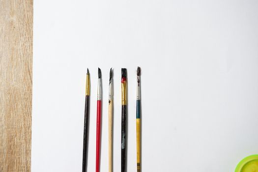 Paper of art work with part of  plate and color brushes