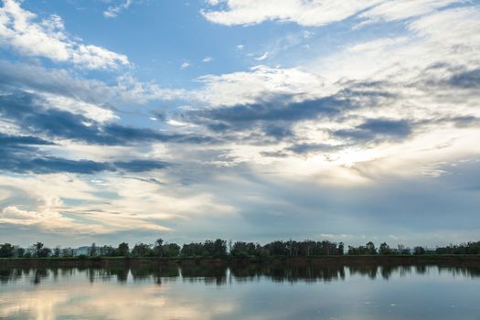 Idyllic landscape. The sky and the forest are reflected in the river.