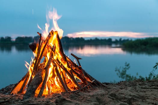 Beautiful bonfire by the river. Evening landscape