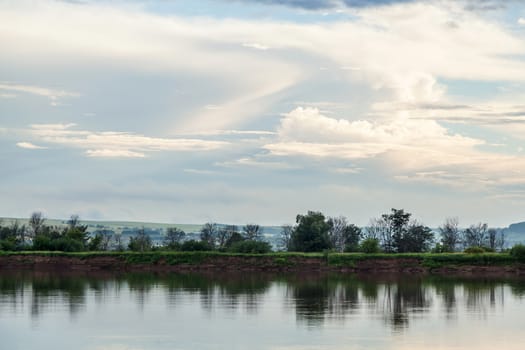 Idyllic landscape. The sky and the forest are reflected in the river.