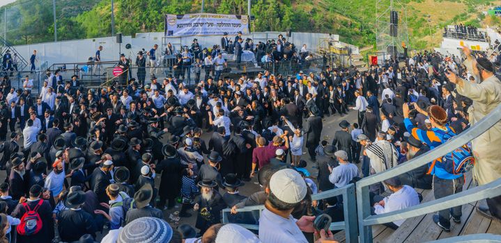 MERON, ISRAEL - MAY 26, 2016: Panoramic view of a crowd of orthodox Jews, attending and dancing at the annual hillulah of Rabbi Shimon Bar Yochai, in Meron, Israel, on Lag BaOmer Holiday