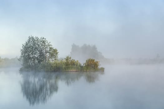 River before sunrise in the fog in the countryside