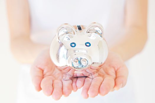 woman holding white piggy bank over body background.