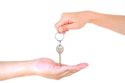Male hand holding a key and handing it over to another person isolated
