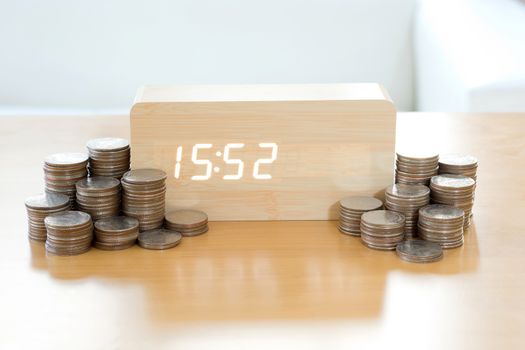 Digital time is money concept. Pound coins in foreground blurred, 