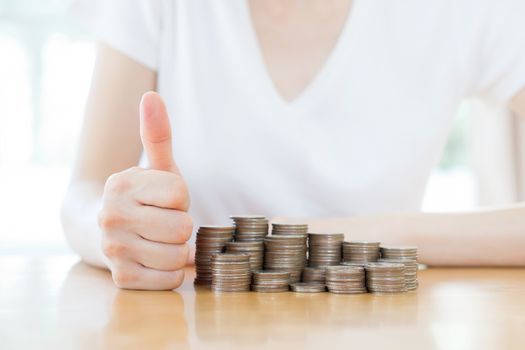 Close-up Of woman's Hands with money coins  on wooden desk