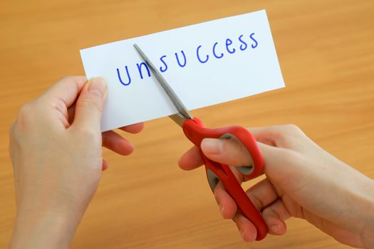 holds card with text unsuccess on wood plate