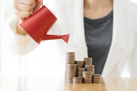hand business woman and red watering can with money
