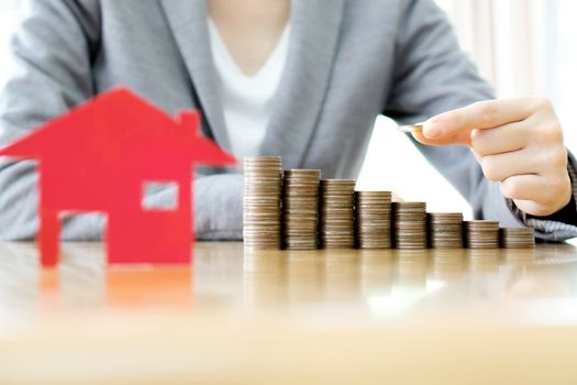 Real estate investment. House and coins on table.