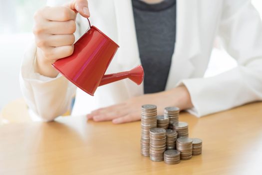 hand business woman and red watering can with money