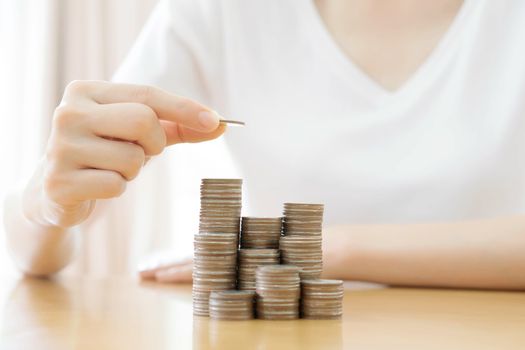 Hand put coins to stack of coins on white background