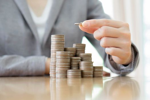 Close-up Of A Businesswoman Making Stack Of Coins