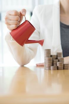 hand business woman and red watering can with money