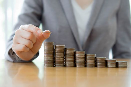 Close-up Of A Businesswoman Making Stack Of Coins