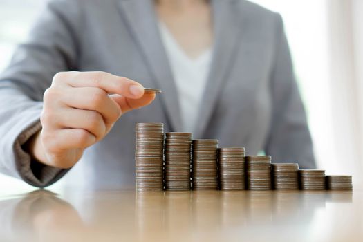 Close-up Of A Businesswoman Making Stack Of Coins