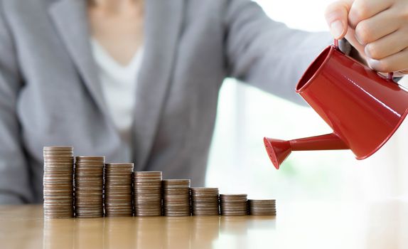 hand business woman and red watering can with money