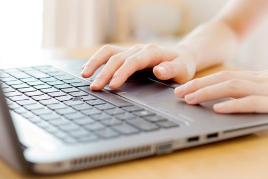 Woman working at home office hand on keyboard close up