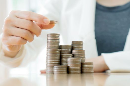 Close-up Of A Businesswoman Making Stack Of Coins