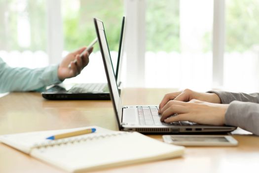 Business people working together on laptop in office at desk