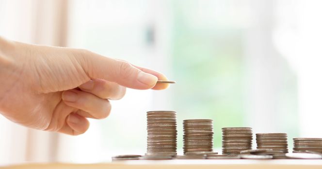 woman put coins to stack of coins
